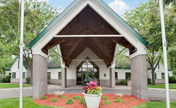 A building with a green roof and a white pillar in front of it.