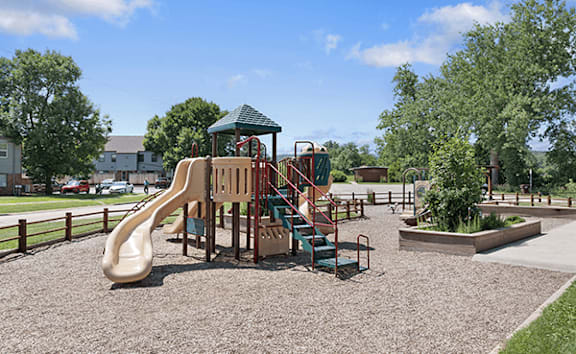 A playground with a slide, swings, and a playhouse.