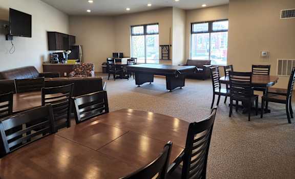 A large room with a long table and chairs.