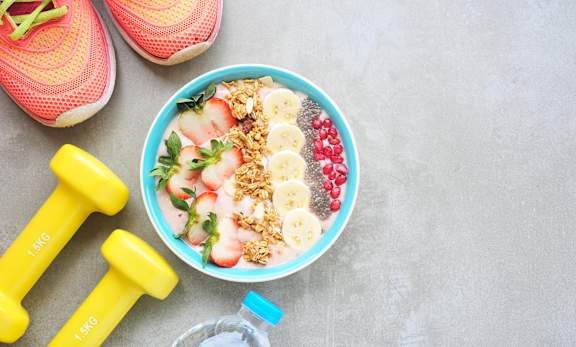a bowl of fruit and granola with a bottle of water