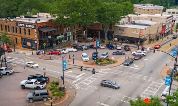 A busy intersection with cars and pedestrians in a town.