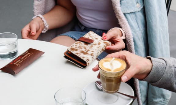 two people sitting at a table with a cup of coffee