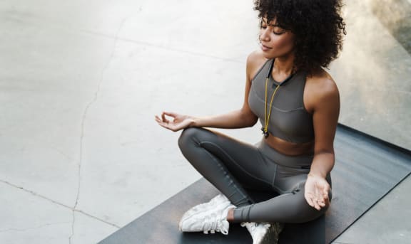 a woman sitting on the floor with her hands on her thighs