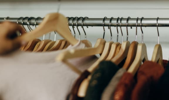 a rack of clothes on a hanger in a closet