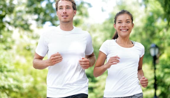 a man and a woman running in a park