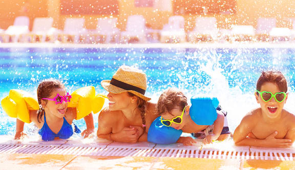 a mother and her children in a swimming pool