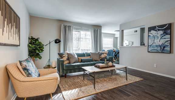 A living room with a blue couch and a television on a wooden cabinet.