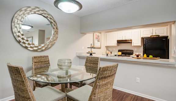 A dining room with a glass table and chairs at Coral Club Apartments in Bradenton