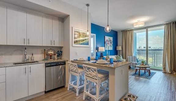 A kitchen with white cabinets and a blue accent wall.