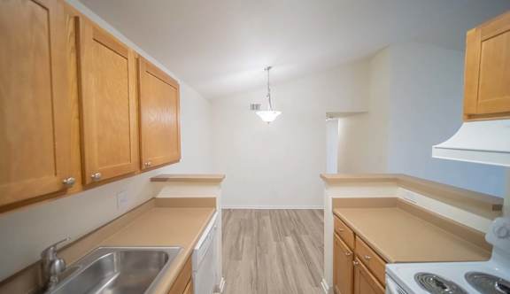 A kitchen with wooden cabinets and a stove top oven.