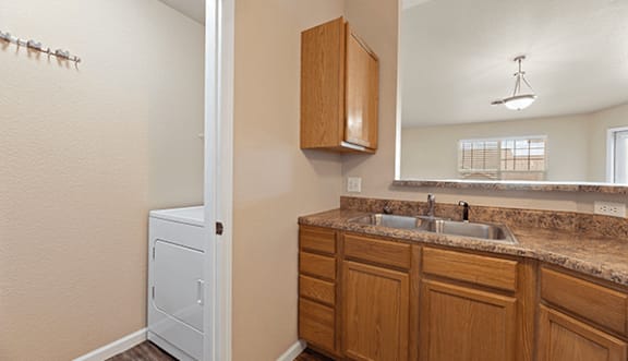 A bathroom with a brown wooden cabinet and a white sink.