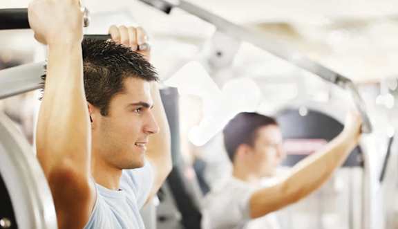 A man is working out on a machine in a gym.