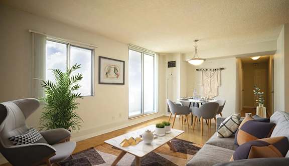 A living room with a grey sofa, a wooden coffee table, and a dining table set up in the background.