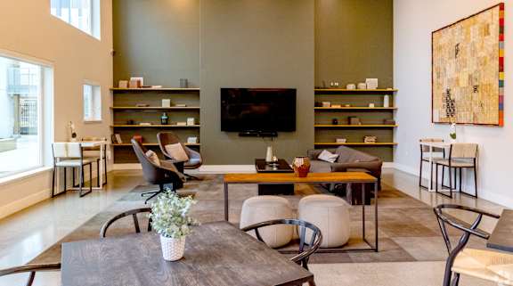 A living room with a grey table and a television on the wall.