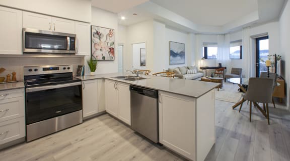 a kitchen and living room with an island and stainless steel appliances