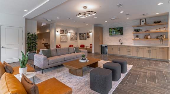 A living room with a grey sofa, orange cushions, and a wooden coffee table.