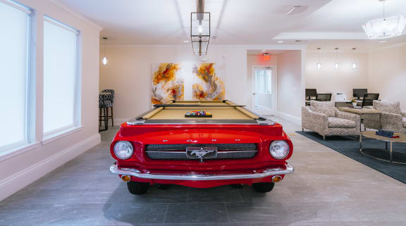 a pool table with a red car on top of it