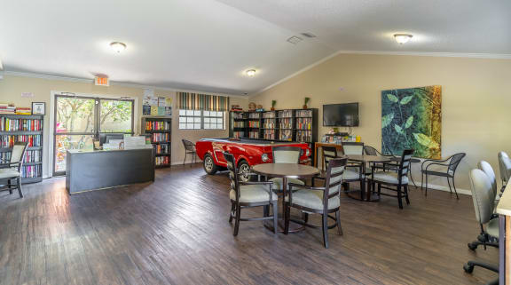 a library with a red car in the middle of the room