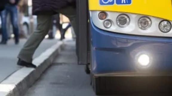 a blue and yellow bus parked next to a curb