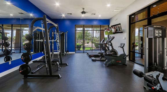a spacious fitness center with cardio machines and other exercise equipment