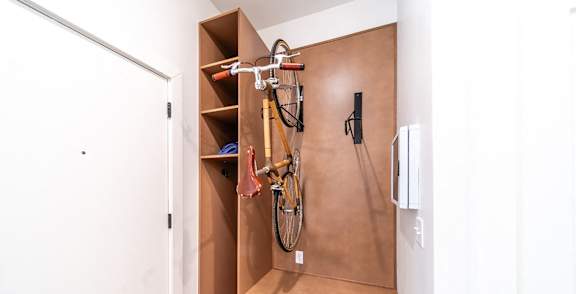 A bicycle is hanging on a rack in a small room.