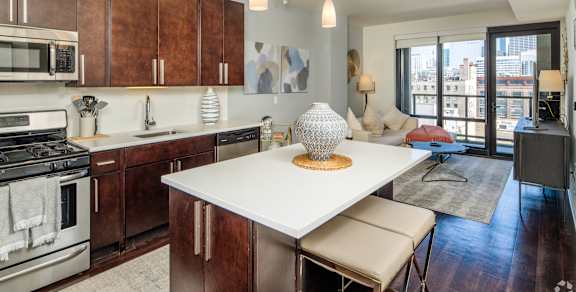 A modern kitchen with a large island and a view of the city.