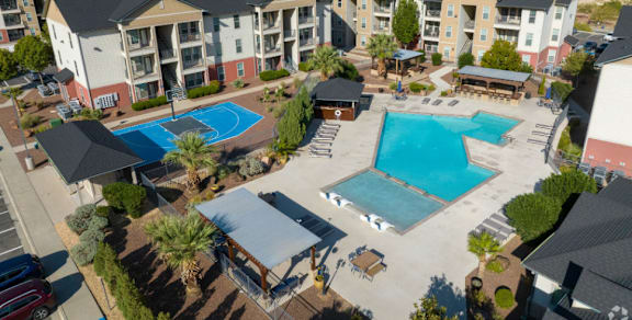 A large apartment complex with a pool and a hot tub.