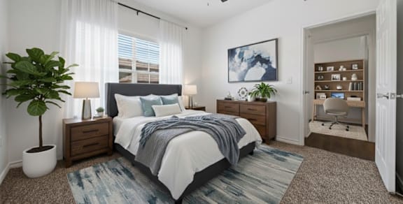 A bedroom with a bed, a plant, and a painting on the wall.