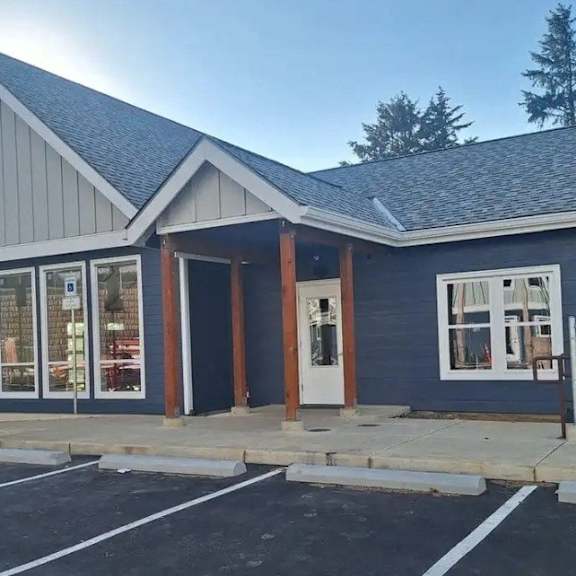 a small building with a parking lot in front.