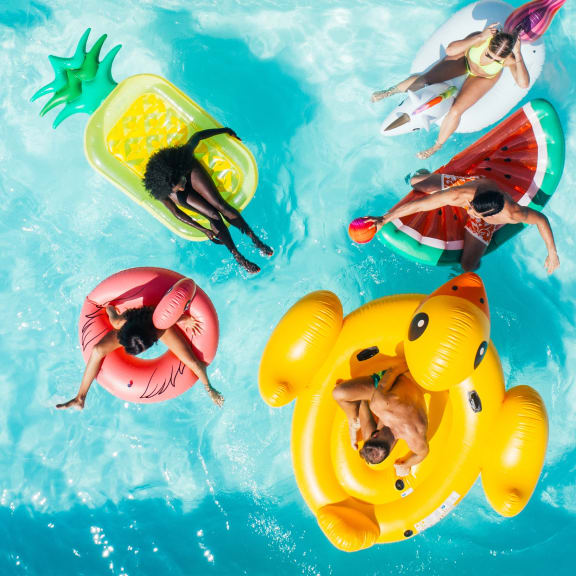 people swimming in a pool on inflatable rafts in the water