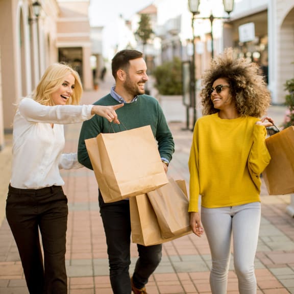 a group of people walking down the street with shopping bags
