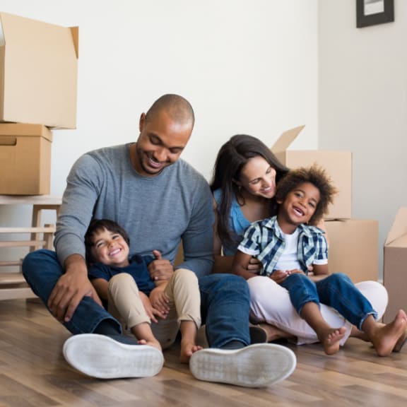 a family sitting on the floor in their new home