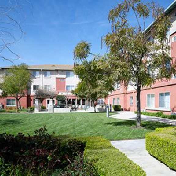a red building with a green lawn in front.