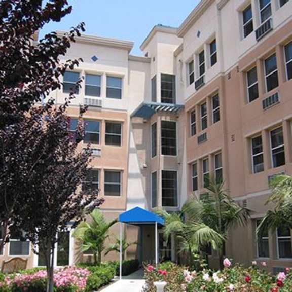 a building with a blue awning and a white fountain in front of it.