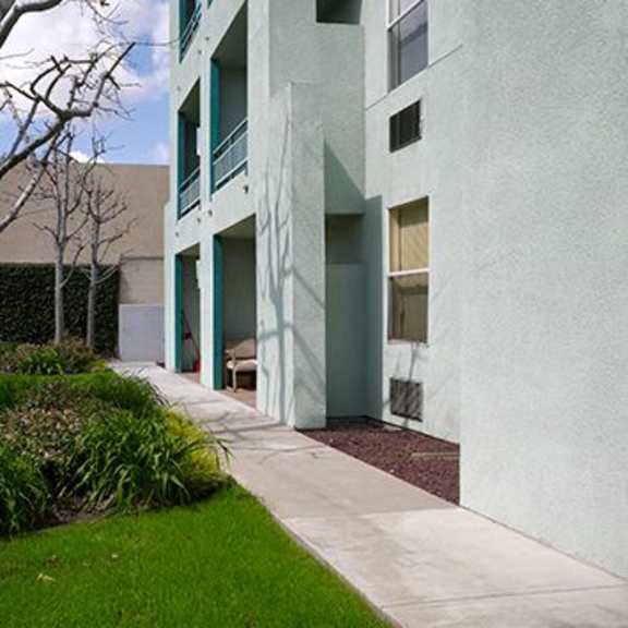 a modern building with a white exterior and a green lawn in front.