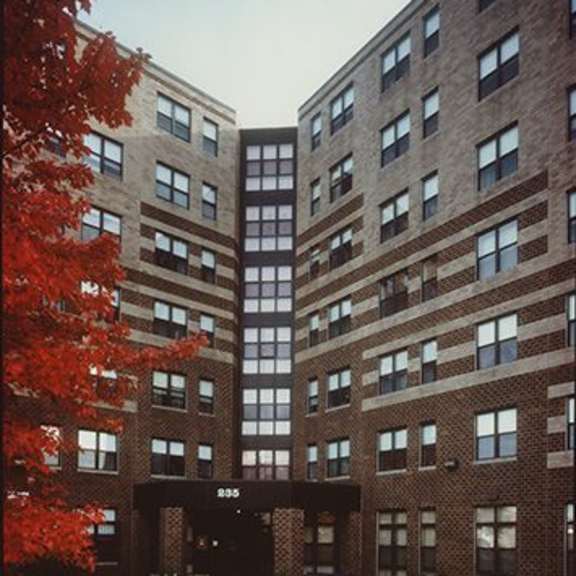 a tall brick building with a black awning in front.