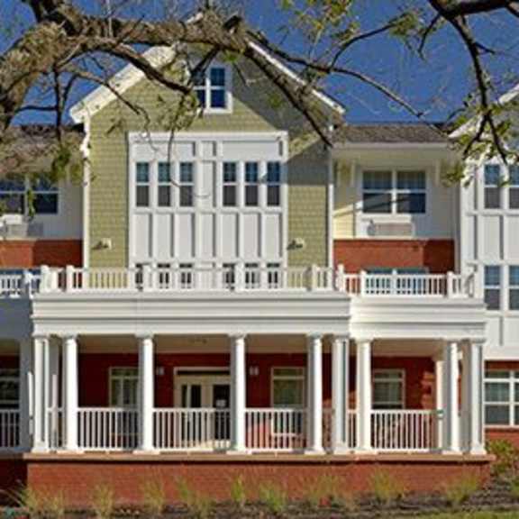 a two story house with a balcony on the bottom floor.