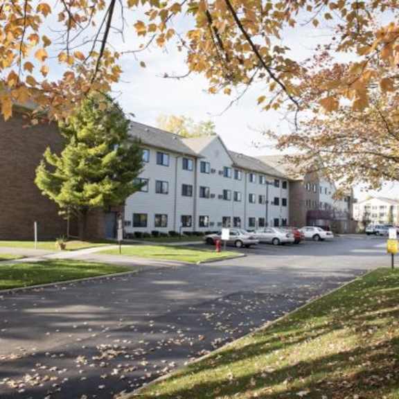 a parking lot in front of a building with cars parked.