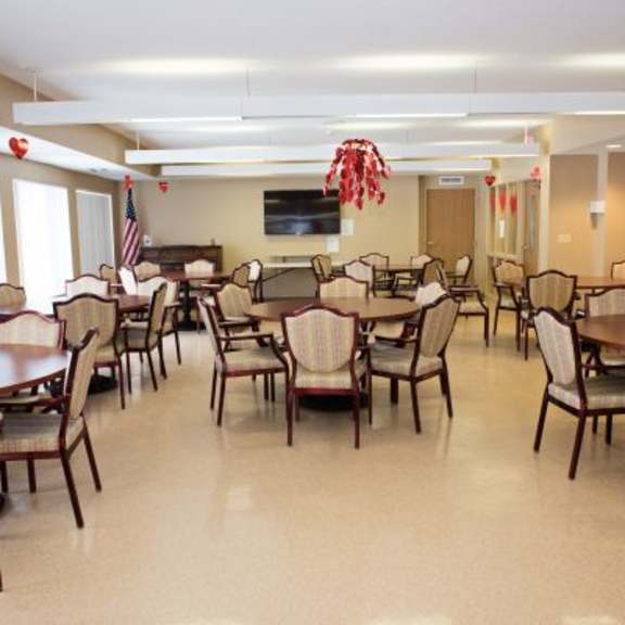 a large room with tables and chairs and a television.
