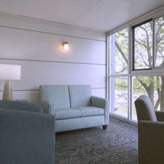a grey couch and chair in a room with a window.
