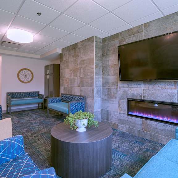 a living room with a fireplace and a flat screen tv mounted on the wall.