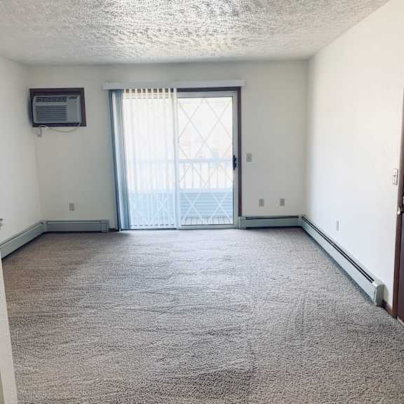 an empty room with a door leading to a balcony