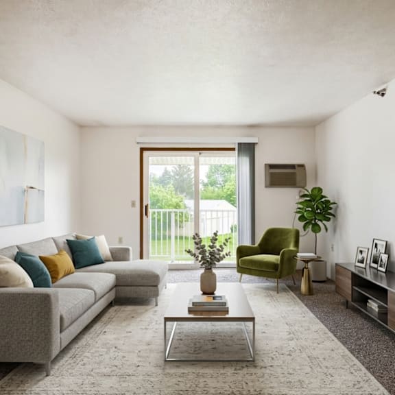 a living room with a grey couch, a green armchair, a coffee table, and a large window.