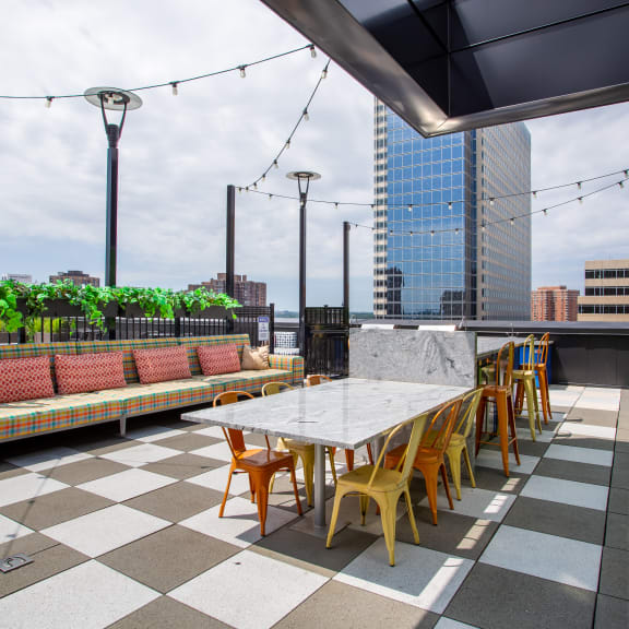 a rooftop patio with tables and chairs and a view of the city