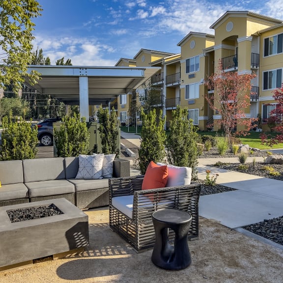 a patio with couches and a coffee table in front of an apartment building