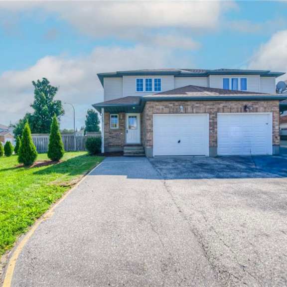 a two-story house with a garage and a driveway.