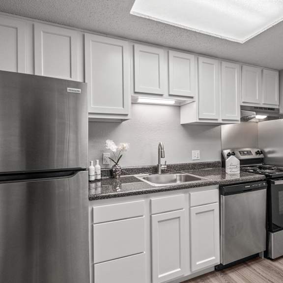 a kitchen with a stainless steel refrigerator and white cabinets.