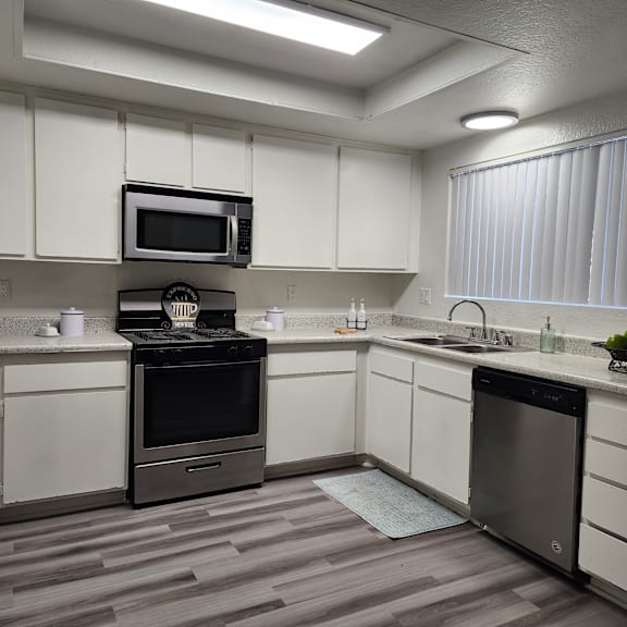 a kitchen with white cabinets and stainless steel appliances