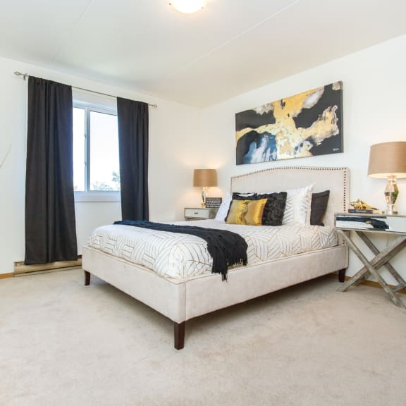 a bedroom with white walls and a beige carpet