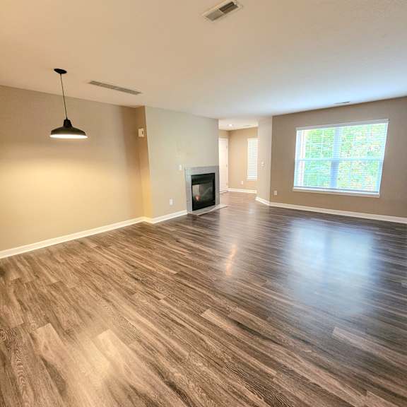 A room with wooden flooring and a television set.